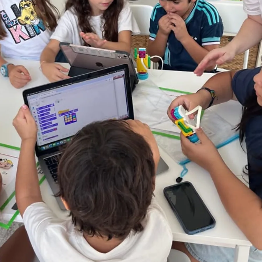 Estudiantes en grupo construyendo y programando el Snackbot con LEGO® SPIKE™ Essential.