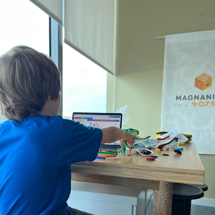 Estudiante de 8 años construyendo su robot Plant Bot con LEGO® SPIKE™ Essential en Magnanibots.